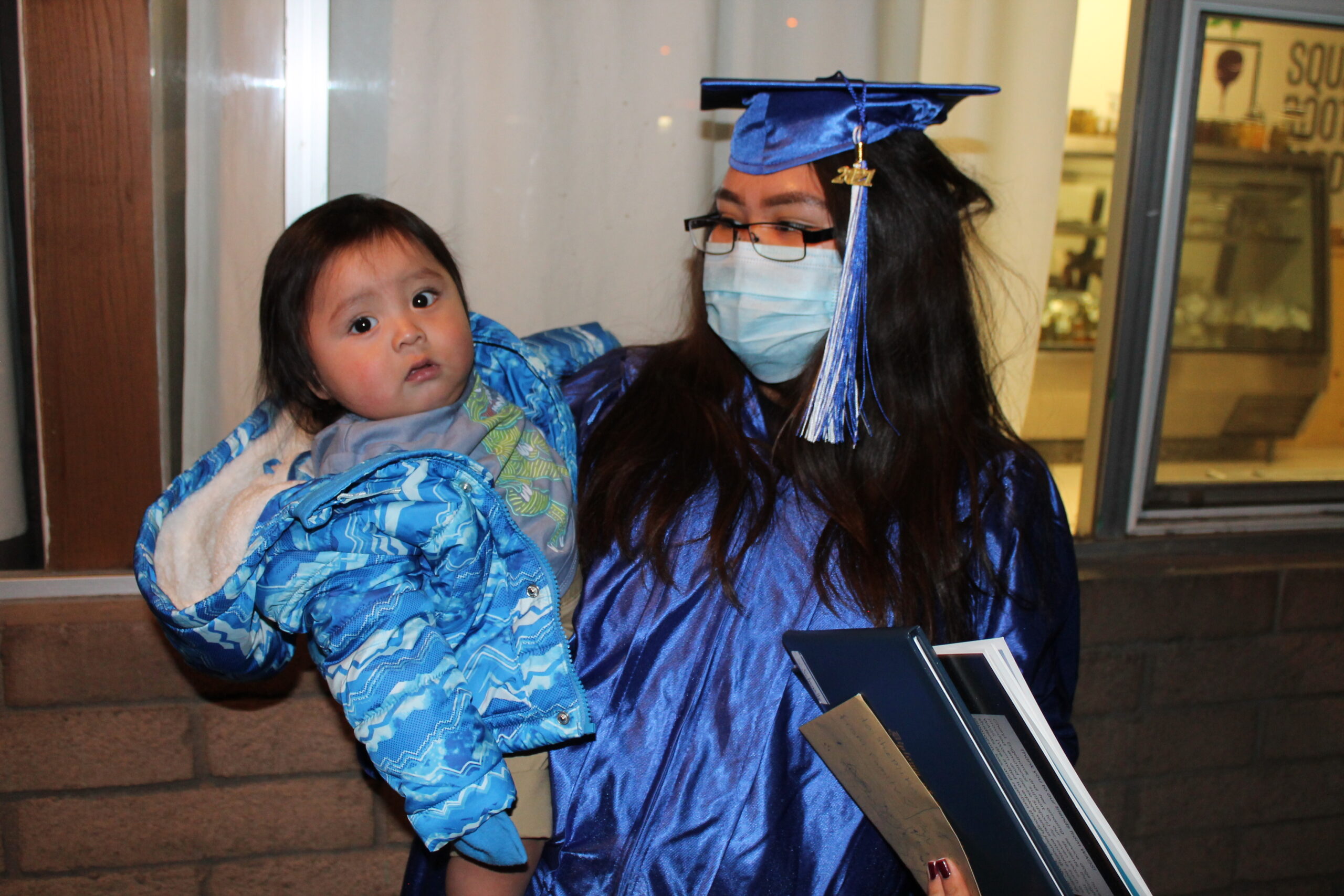 Student Holding Child at Graduation